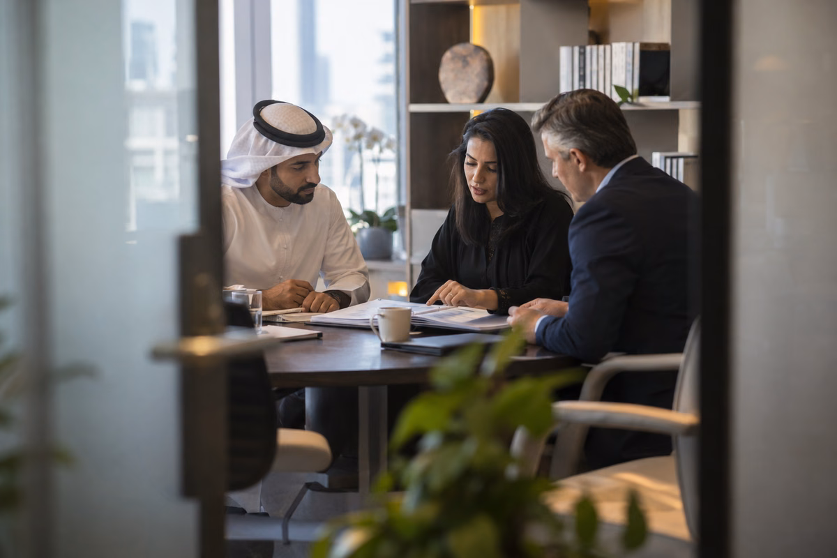 Three business professionals discussing year-end financial records in a meeting room
