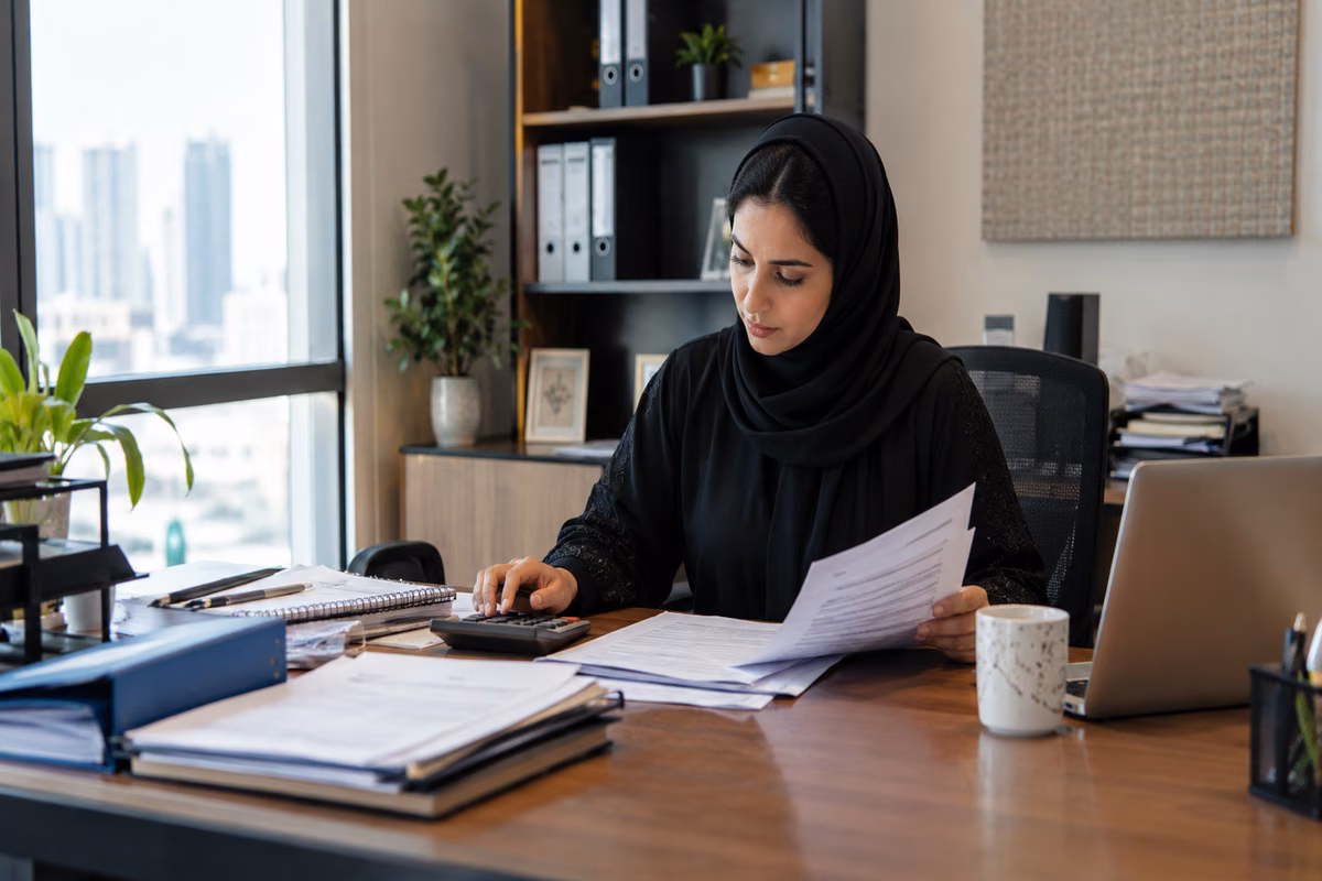 Payroll specialist reconciling records at a desk